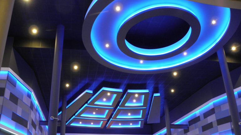 Modern interior featuring blue LED lighting and an elaborate ceiling design.