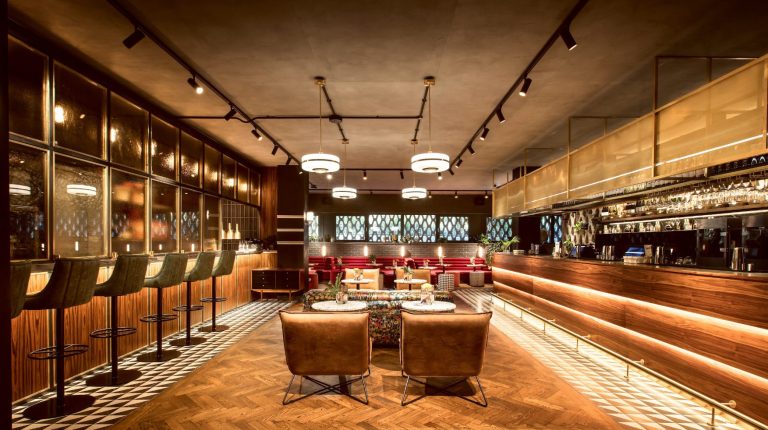 Modern bar interior with elegant seating and a well-lit, stylish atmosphere.